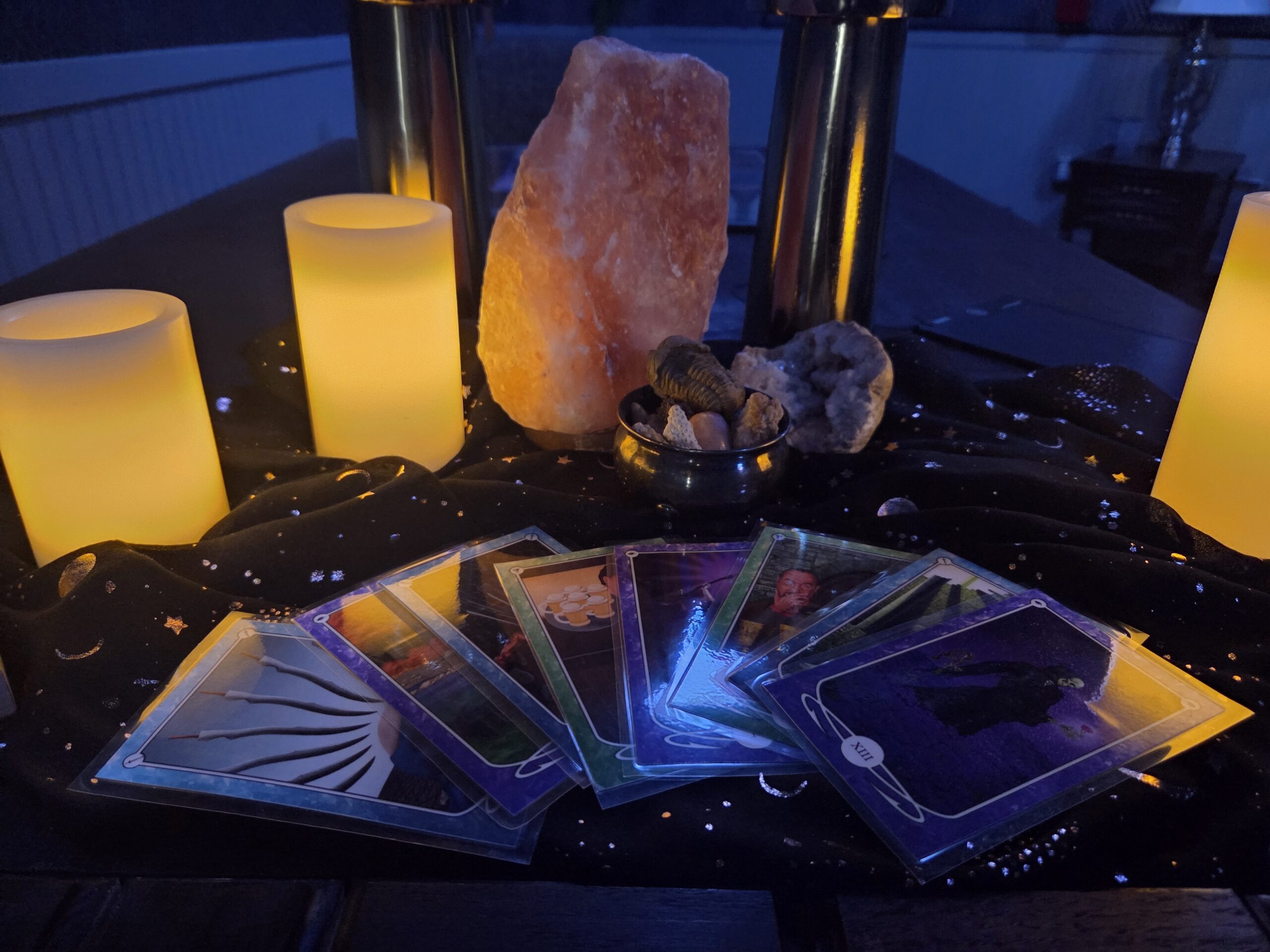 Inside the escape room. A spread of tarot cards in front of a crystal, illuminated by candles.